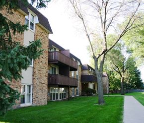 Mankato apartment for rent - a brick apartment building with green grass and trees