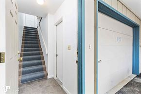 Anchorage apartment for rent - A staircase with a blue carpeted runner leads up to a white door with a number 367 on it.