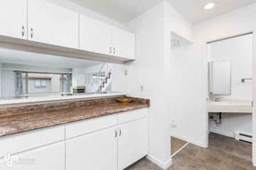 Anchorage apartment for rent - A modern kitchen with white cabinets and a wooden countertop.