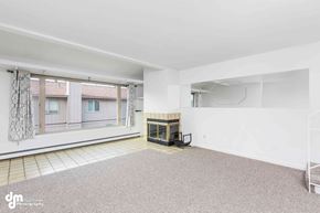 Anchorage apartment for rent - A spacious room with a fireplace and a window overlooking a balcony.