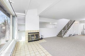 Anchorage apartment for rent - A spacious living room with a fireplace and a staircase.