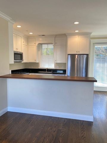 Sonoma house for rent - A kitchen with white cabinets and a wooden island.