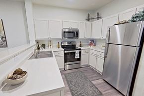 West Linn apartment for rent - a kitchen with stainless steel appliances and white cabinets