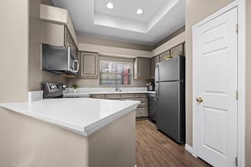 Denver apartment for rent - A kitchen with a white countertop and a black refrigerator.