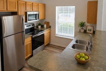 Thornton apartment for rent - A kitchen with a refrigerator, microwave, oven, sink, and a bowl of apples on the counter.