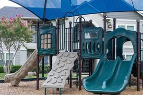 Grapevine apartment for rent - A playground with a green slide and a brown sandbox.