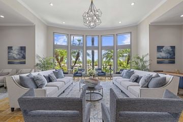 Orlando apartment for rent - A well-lit living room with a grey sofa set and a chandelier.