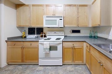 Redmond apartment for rent - A kitchen with wooden cabinets and a white stove top oven.