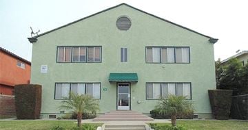 Wilmington apartment for rent - a green building with a green awning and trees in front of it