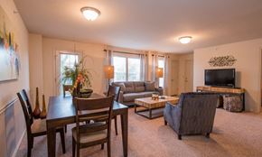 Oklahoma City apartment for rent - A living room with a couch, chairs, and a television.
