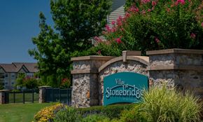 Edmond apartment for rent - A sign for Villas Stonebridge is in front of a green fence.