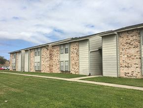 Port Arthur apartment for rent - an apartment building with gray and white siding and a green lawn
