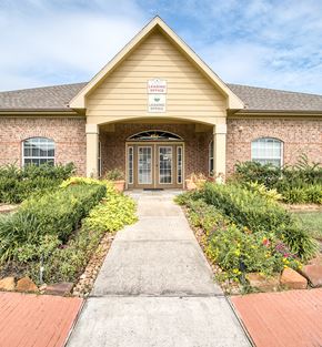 Orange apartment for rent - the front of a house with a walkway and plants in front