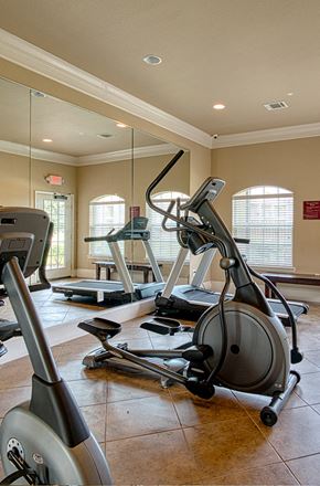 Orange apartment for rent - a gym with treadmills and other exercise equipment in a home gym