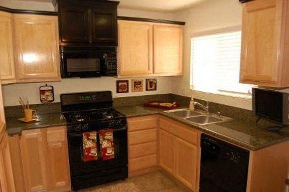 Westminster apartment for rent - A kitchen with wooden cabinets and black appliances.