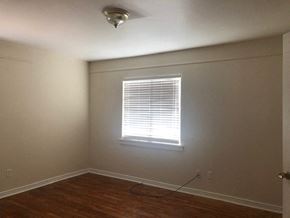 Snyder house for rent - A room with a window and wooden floors.