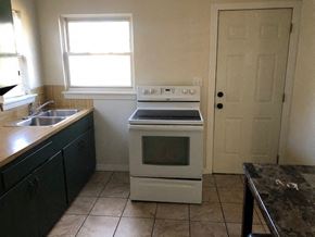 Snyder house for rent - A kitchen with a white oven and black cabinets.