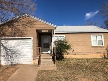 Snyder house for rent - A house with a brown facade and a white garage door.