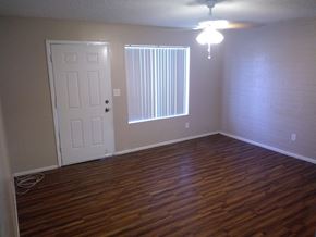 Goodyear apartment for rent - an empty living room with wood floors and a white door