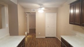 Goodyear apartment for rent - an empty kitchen with a white door and a ceiling fan