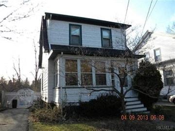 Poughkeepsie house for rent - A white house with a black roof and a tree in front of it.