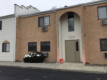 Wappingers Falls apartment for rent - A building with a brown facade and a grey door.