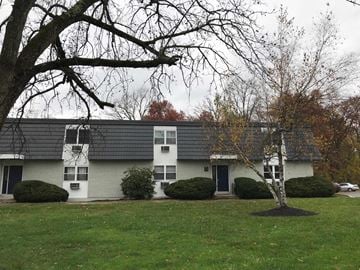 Wappingers Falls apartment for rent - A white house with a grey roof and a tree in front.