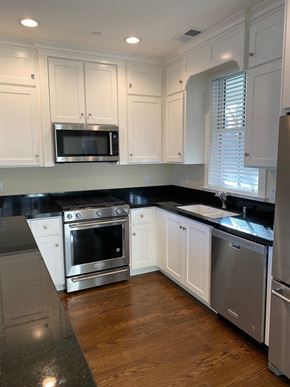 Sonoma house for rent - a kitchen with white cabinets and stainless steel appliances