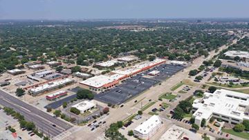 Plano apartment for rent - an aerial view of a parking lot and buildings in a city