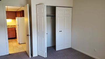 Zion apartment for rent - A kitchen with a refrigerator and a pantry with a door open.
