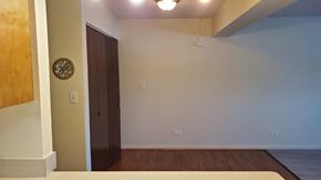 Zion apartment for rent - A room with a brown door and a white wall with a clock on it.