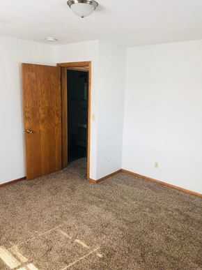 Moorhead apartment for rent - A room with a brown door and carpet.