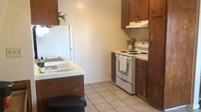 San Luis Obispo apartment for rent - A kitchen with a white fridge, white stove, and brown cabinets.