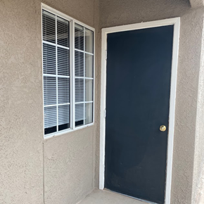 El Paso apartment for rent - A black door with a gold knob is on the right and a window with white blinds is on the left.