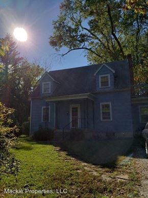 Bloomington house for rent - a blue house with the sun shining behind it