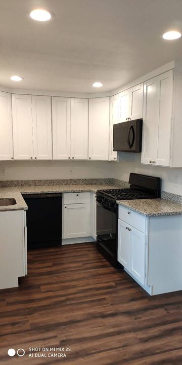 Olivehurst apartment for rent - a kitchen with white cabinets and a black stove