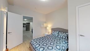Ottawa apartment for rent - A bedroom with a bed and a mirror.