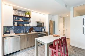 Washington apartment for rent - a kitchen with a white table and red chairs and a sink
