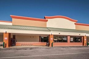 Tarpon Springs apartment for rent - A storefront with a red and green roof and a parking lot in front.