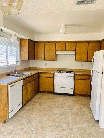 Arroyo Grande apartment for rent - A kitchen with wooden cabinets and white appliances.