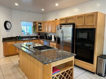 Arroyo Grande apartment for rent - A kitchen with wooden cabinets and granite countertops.