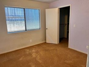 Grover Beach house for rent - A room with a carpeted floor, a window with blinds, a door, and a wall socket.