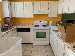 Atascadero apartment for rent - A kitchen with white cabinets and a white stove top oven.