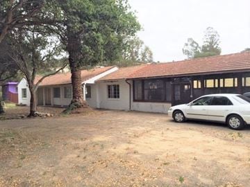 Grover Beach apartment for rent - A white car is parked in front of a building with a red roof.