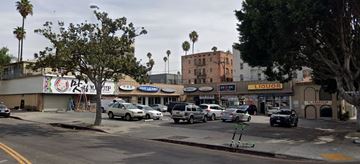 Los Angeles apartment for rent - a busy city street with cars parked in front of stores