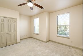 Covington apartment for rent - an empty bedroom with a ceiling fan and two windows