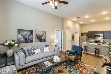 Colorado Springs apartment for rent - a living room and kitchen with a couch and a chair