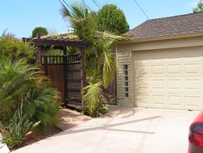 San Diego apartment for rent - A house with a white garage door and a brown pergola.
