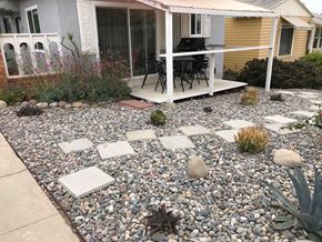 San Diego apartment for rent - A patio with a table and chairs is surrounded by a gravel area with stepping stones.