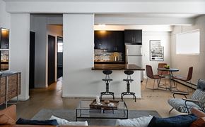 Denver apartment for rent - A modern living room with a glass coffee table and a bar area.